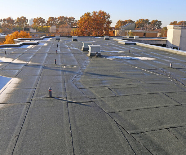 Building with newly renovated flat roof sealing