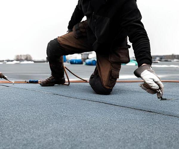 worker on a modified bitumen roof