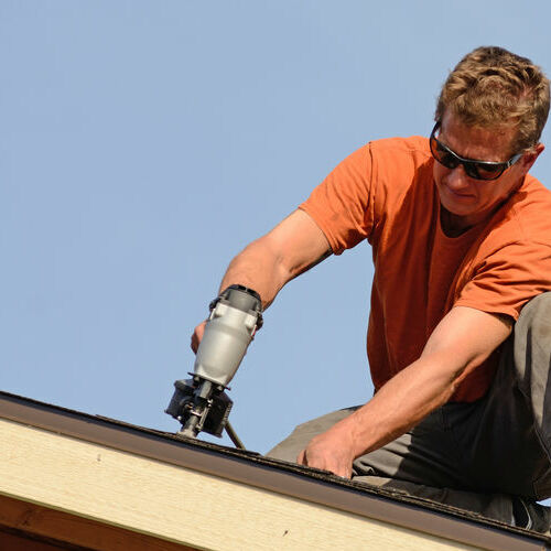 Roofer works on roof.