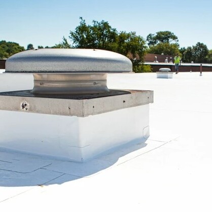 Roofer walks commercial roof.