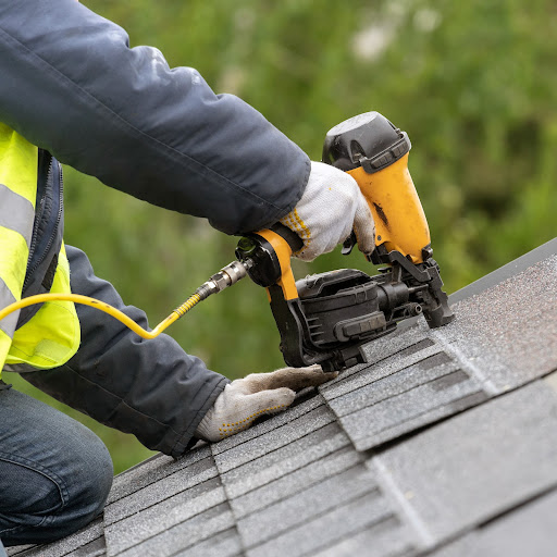 Roofer installs shingles.